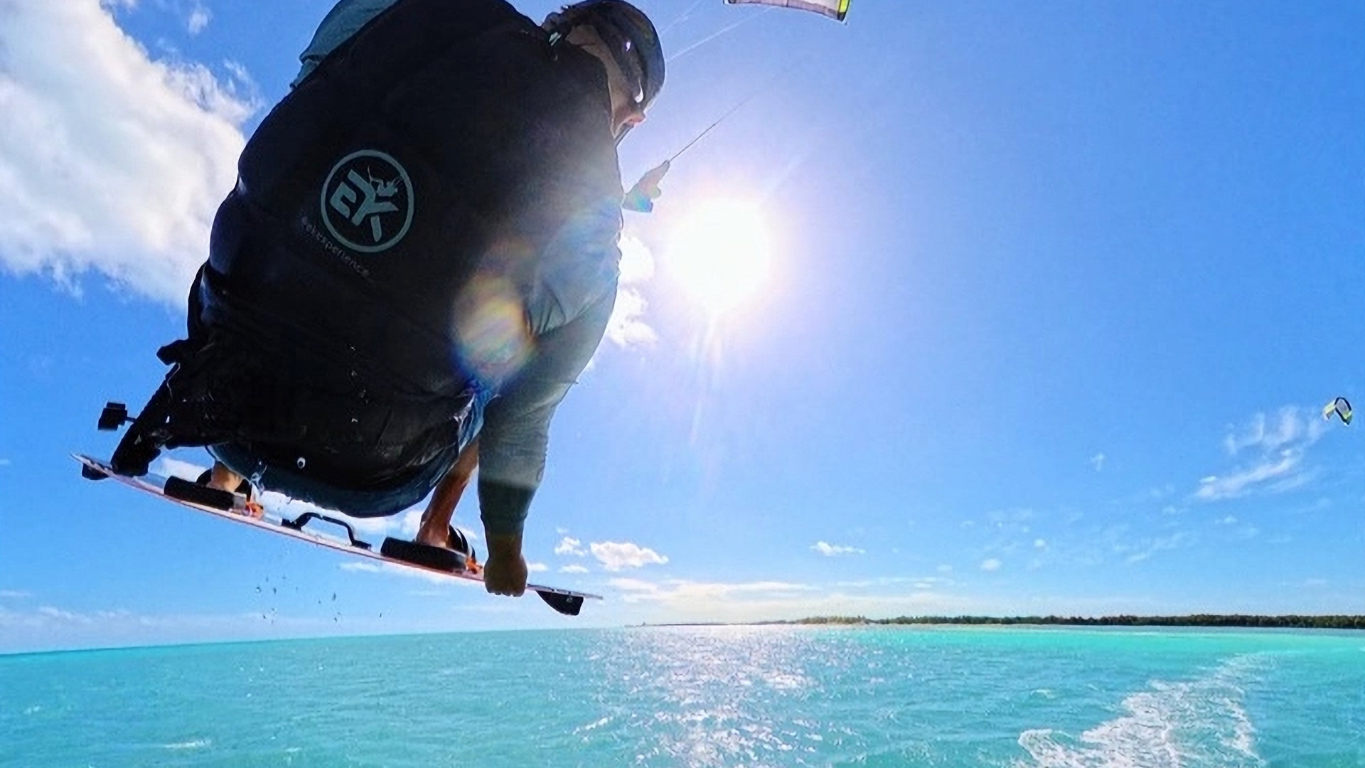 EK Experience rider boosting a jump with a board grab over turquoise water